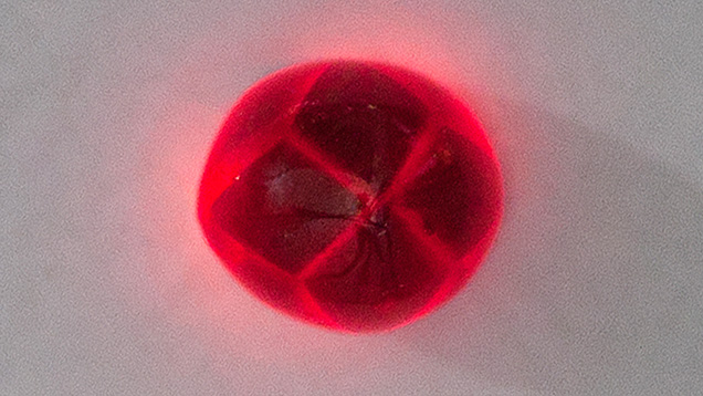 Figure 2. This 3.57 ct garnet emits vivid red through the trapiche patterns when shining a flashlight through the gem. Photo by Le Ngoc Nang.