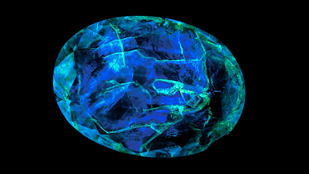 Figure 13. The epoxy filling of this clarity-enhanced emerald fluoresces blue under 365 nm illumination. From Tsai (2021).