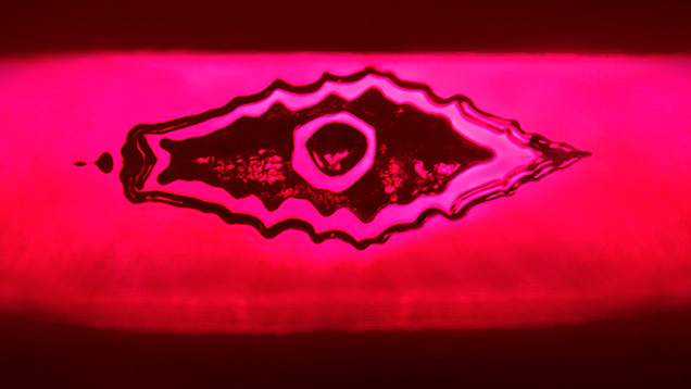 The reflection of a flux-healed fissure from a step pavilion facet in this Mong Hsu ruby resembles an evil eye. Photomicrograph by Ungkhana Atikarnsakul; field of view 1.07 mm.