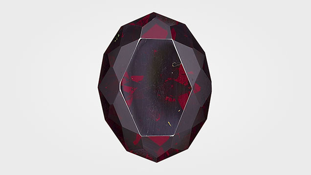 Figure 1. A 100.15 ct faceted cuprite, measuring 29.37 × 22.29 × 14.09 mm, the largest ever submitted to GIA. Photo by Diego Sanchez.