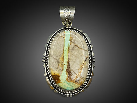 Figure 3. “Old stock” stabilized green Mona Lisa turquoise in novaculite matrix set in a silver ribbon pendant. Photo courtesy of White Horse Resale.