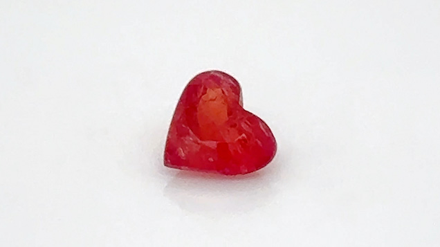 Figure 7. A 0.67 ct heart-shaped pezzottaite measuring 5.61 × 6.10 mm. The rough of this rare newer gem material was found and bought in Madagascar in December 2023. The stone was cut in New York for the Tucson show, where it sold. Photo by Kalim Corey; courtesy of Caroline C.