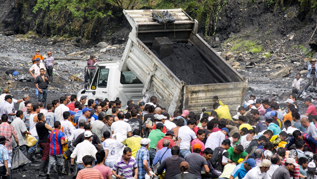 MTC trucks empty ore along the Río Itoco