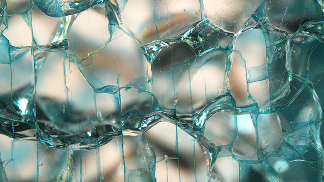 Figure 3. Dye concentrations along shallow, weblike induced fractures evenly spaced across the surface of a colorless laboratory-grown sapphire. Photomicrograph by Jamie Price; field of view 5.50 mm.