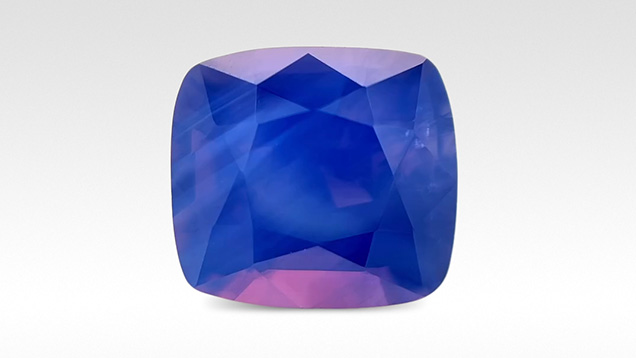 Figure 3. An exceptional 5.02 ct, 9.9 × 9.0 mm opalescent blue sapphire from An Phu, Vietnam, with eye-visible bands of silk in addition to pink and orange flashes reminiscent of play-of-color in opal from Australia. Photo by Anna Merritt; courtesy of Dudley Blauwet Gems.