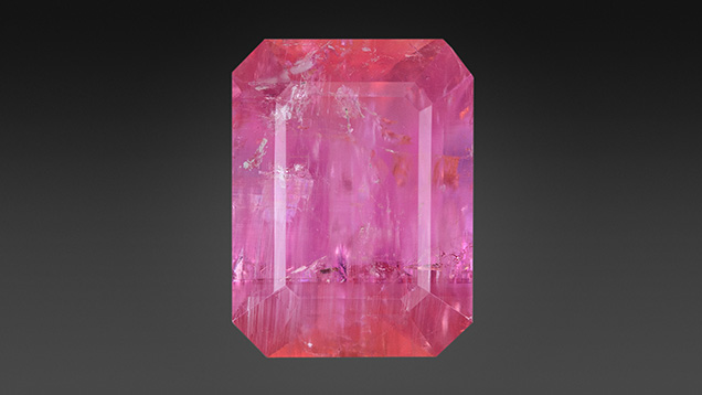 Figure 1. This 8.13 ct pezzottaite contains delicate growth banding (~horizontal) and tube inclusions (~vertical, seen best in lower left). Photo by Adriana Robinson.