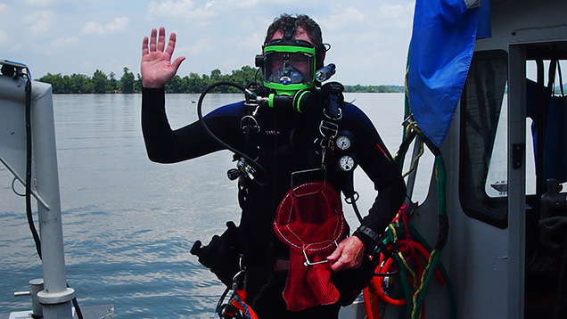 潜水员在船上挥动蚌