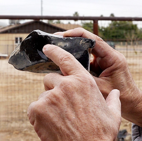 Figure 3. Dodge describes taking a chip off of the rough. This provides a “window” into the stone so he can spot flow bands in the glass. The flow bands give rise to the phenomenal colors, and provide guidance in his lapidary work. Photo by Pedro Padua.