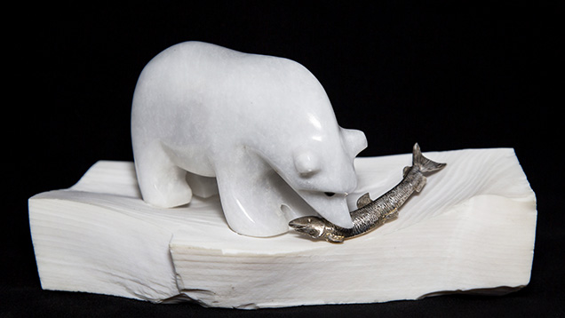 A petrified opalized wood stand supports this marble polar bear.