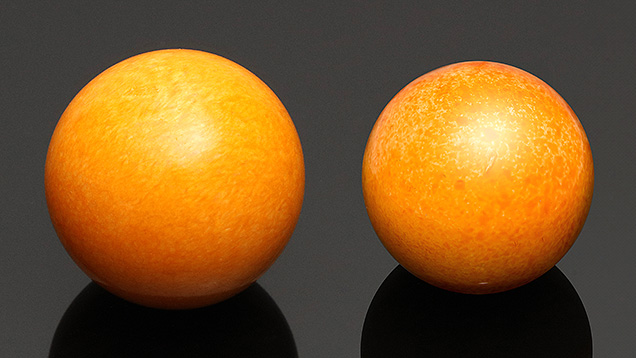 Figure 1. A 140.58 ct dyed calcite sphere (left) and an 89.81 ct round dyed and coated shell (right), both resembling Melo pearls. Photos by Johnny (Chak Wan) Leung (left) and Lhapsin Nillapat (right).