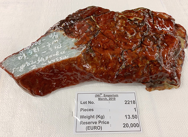 Rough jadeite boulder with a thin reddish brown skin.
