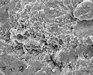 Figure 18. An SEM image of sample S3 reveals well-formed quartz particles approximately 5 μm in diameter, with a hexagonal cross section left by a fracture. Fibrous chalcedony is observed at the border transition.