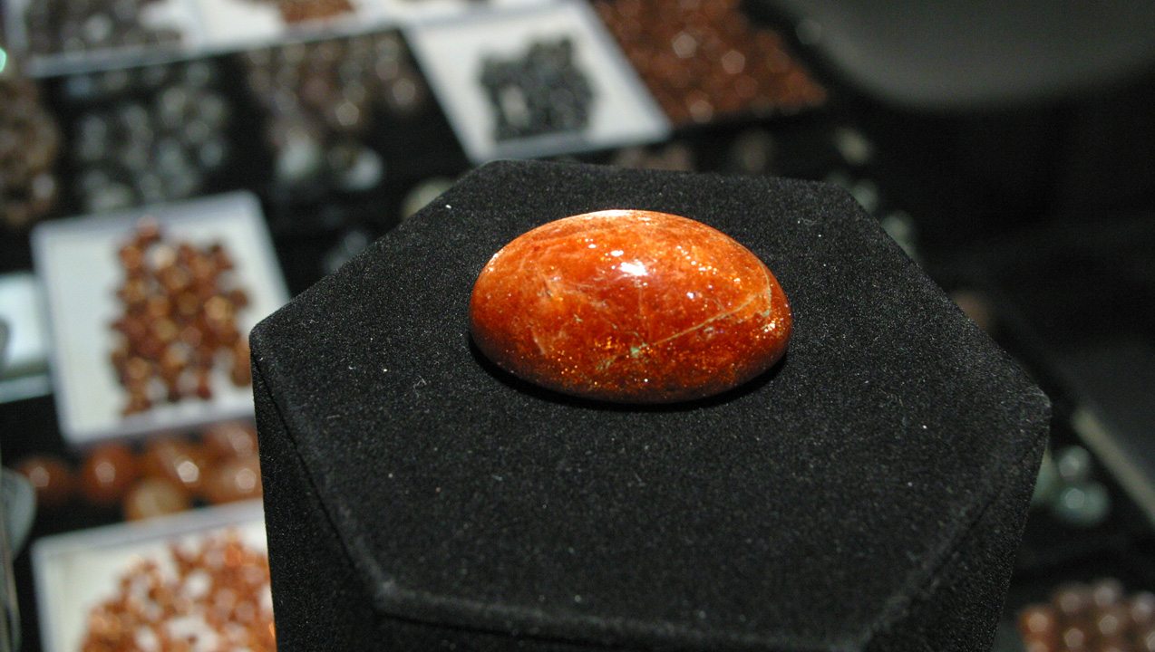 この146.07カラットの珍しいサイズの 灰曹長石により、後ろの日長石、ムーンストーンなどの宝石が小さく見えます。 - Terri Weimer（テリー・ワイマー）、提供：Blue Moon Enterprise（ブルームーンエンタープライズ）