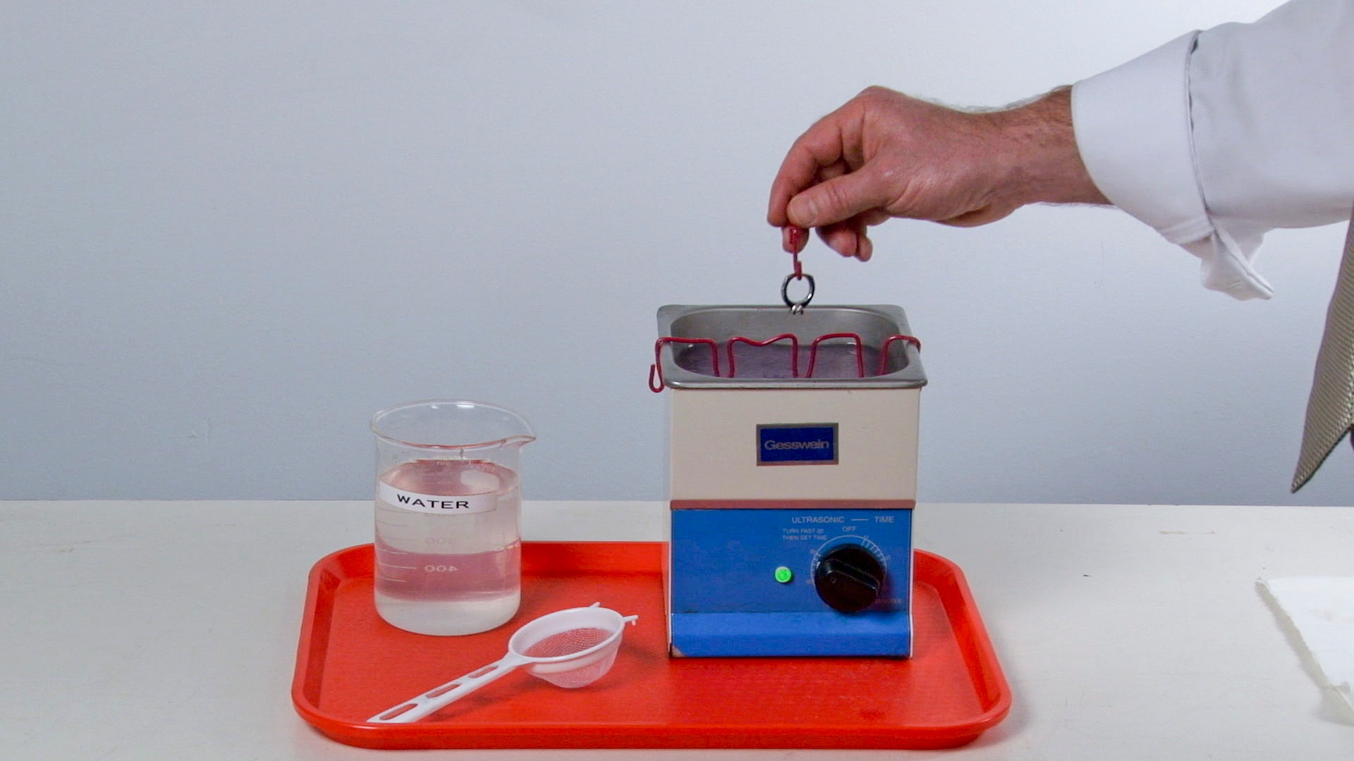 Close-up view of a jeweler cleaning a platinum solitaire in preparation for prefinishing