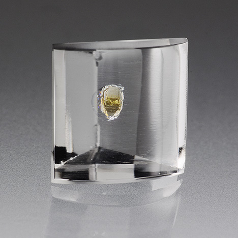 A transparent yellow crystal can be seen in a 10.54 ct rock crystal quartz host.