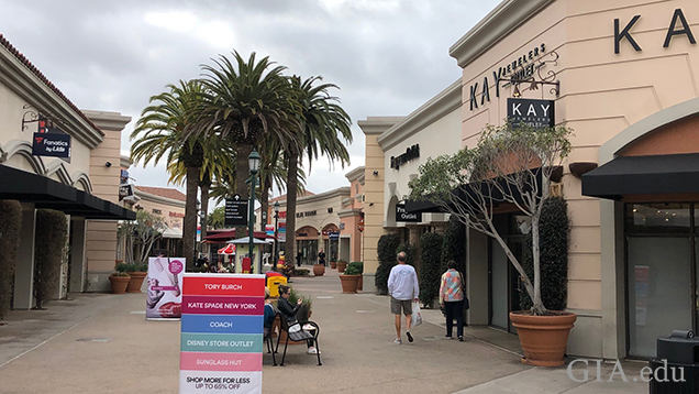 ケイ ジュエラーズの店頭を通り過ぎる2人。