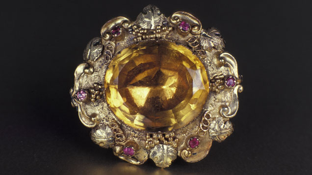 A brooch from the Victorian era features an oval citrine with six ruby accent stones. - GIA & Tino Hammid