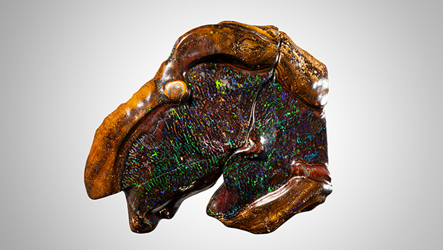 Broken boulder opal with light pattern of color.