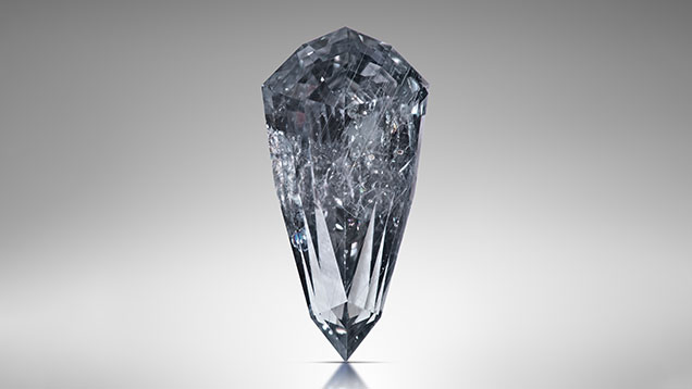 Figure 2. This 3.49 ct sapphire (sample RK-FBS 030) measuring 13.23 mm long was faceted from an 11.15 ct rough crystal in basaltic trachyandesite matrix recovered from the French Bar sill. A combination of diffused daylight-equivalent (6500 K) LED monolights from the front and a narrow beam of light from behind accentuate both the Rose channel inclusions and the bodycolor. Photo by Jeff Mason.