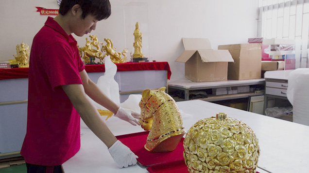 Chinese worker with gold statue