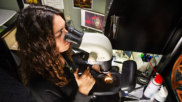 Figure 3. A GIA gemologist examines a diamond’s internal and external clarity characteristics using a gemological microscope. Photo by Kevin Schumacher.