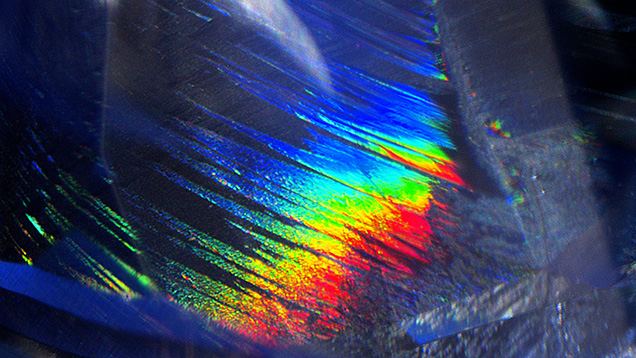 Iridescent partially healed fissure observed in a 4.13 ct blue sapphire. Photomicrograph by Kanako Otsuka; field of view 2.12 mm.