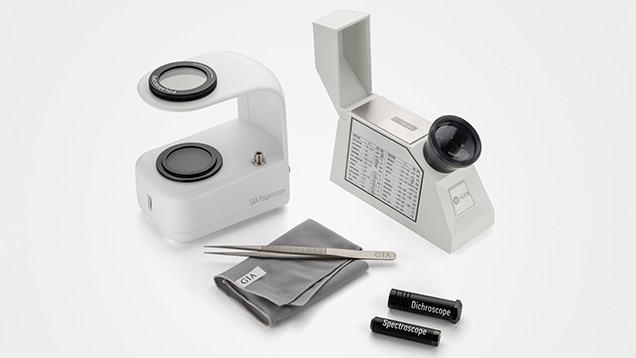 Figure 6. Clockwise from top left: A polariscope, refractometer, dichroscope, and spectroscope are shown with a gem cloth and tweezers. Photo by Emily Lane.