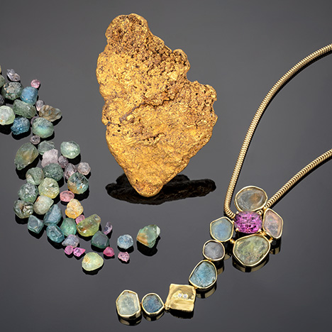 Figure 5. Early gold prospecting led to the discovery of Montana sapphire. This gold nugget from Scratchgravel Hills measures about 4 × 7 cm; courtesy of Bill Larson. The rough sapphires and the necklace containing rough sapphires and a 3.5 ct lavender spinel cut by Larry Woods are courtesy of Diana Widman. Photo by Robert Weldon.