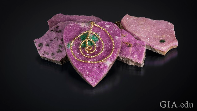 A heart-shaped piece of pink drusy hangs from a gold chain.