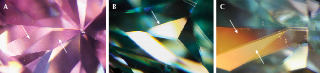 Figure 1. Microscopic images of pink sample PM01 (A) and blue sample BM01 (B and C). A: The white arrows indicate regions where the color is unevenly distributed on the surface of a facet. B and C: The white arrows indicate regions with differences in luster between the upper and lower portion of the pavilion facets and a bronze-colored appearance. Photomicrographs by Tsung-Jen Wu; field of view 4 mm.