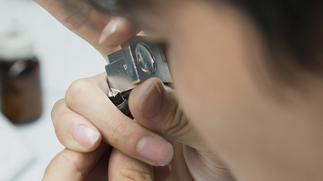 Man looking through loupe