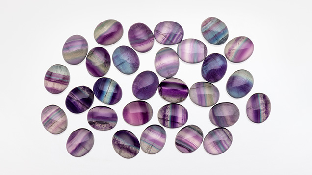 Figure 4. Rainbow fluorite cabochons measuring 10 × 12 mm. Photo by Kevin Schumacher; courtesy of Jennifer Stone-Sundberg.