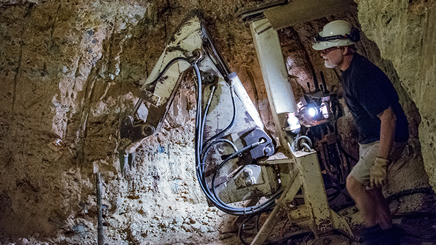 地下で採掘具を使用する男性