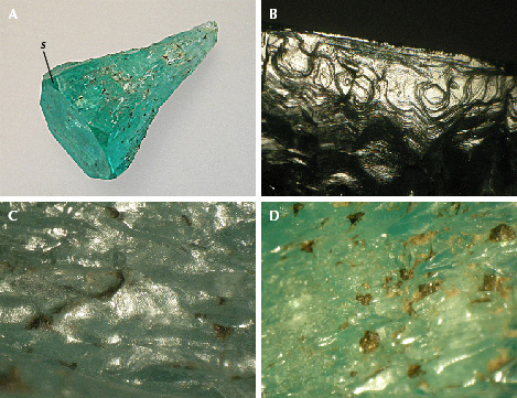 Figure 10. A: Sample 9 (20.8 mm in length), an emerald crystal with conical shape, with basal pinacoid <em>c</em>, small <em>m</em> prism faces, and hexagonal <em>s</em> dipyramids. B: Growth steps on the surface of one of the <em>m</em> prism faces, viewed almost perpendicular to the <em>c</em>-axis. C: Hillocks with fine micro-steps between irregularly shaped groves on the surface of the conical part. D: Residual dark gray carbonaceous material captured in indentations on the surface of the conical part. Photos by K. Schmetzer; fields of view 4.5 mm (B), 3.5 mm (C), and 7.6 mm (D).