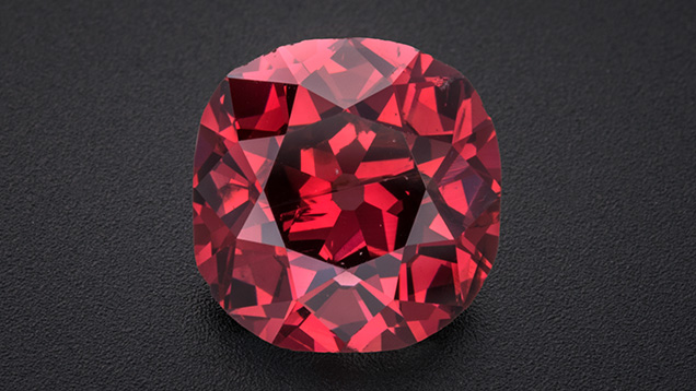 Figure 1. The 2.33 ct Winston Red diamond, displaying a vibrant Fancy red color. The old mine brilliant-cut stone measures approximately 8 mm in diameter. Photo by Robert Weldon; courtesy of Ronald Winston.