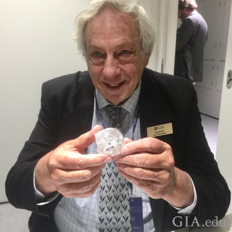 Man holds large rough diamond.