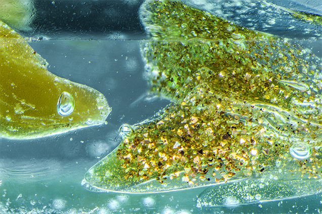 Light yellow goldstone glass containing copper crystals and gas bubbles.