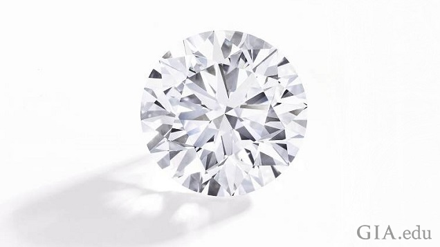 A large pear shaped diamond sits on a silver plaque with French words.