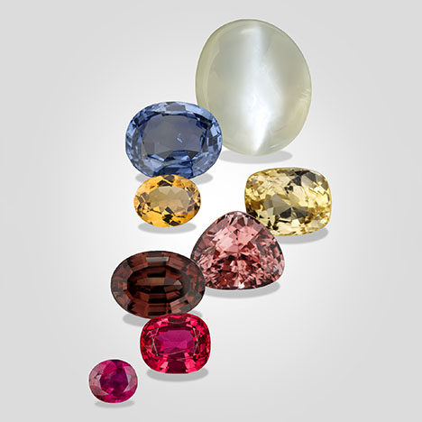 Figure 1. Composite of Burmese gemstones from the Mogok region, from top to bottom: 59.94 ct moonstone, 9.10 ct blue sapphire, 4.67 ct orangy yellow tourmaline, 6.75 ct yellow sapphire, 8.09 ct pink scapolite, 7.19 ct reddish brown zircon, 4.79 ct red spinel, and 1.65 ct ruby. Photos of the moonstone and zircon by Orasa Weldon; all others by Robert Weldon. Courtesy of GIA’s Dr. Edward J. Gübelin collection.