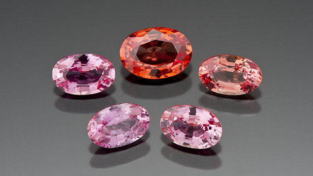 Figure 1. Gem laboratories saw an unusual influx of padparadscha-colored sapphires in the early 2000s and quickly attributed their color to beryllium diffusion. This group of pink and orangy pink treated sapphires ranges from 0.51 to 0.84 ct. Photo by Kevin Schumacher.