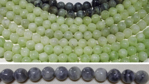 A collection of round beads in varying shades of green and gray, arranged in two rows.