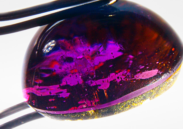 Side view shows the cemented plane of the cabochon assemblage.