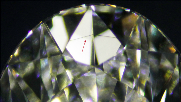 Figure 1. A growth remnant appeared as a color band (arrow) in a 3.14 ct CVD-grown diamond. Photomicrograph by Raju Jain; field of view ~11.75 mm.
