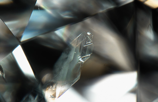 Diamond crystal inclusion exhibits triangular etch features.