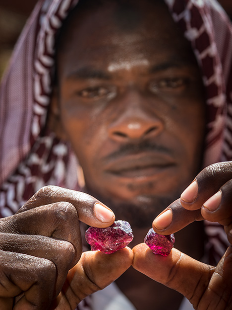 A miner in northern Tanzania examines rhodolite.