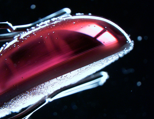 Side view of alexandrite cabochon showing inclusions near base.