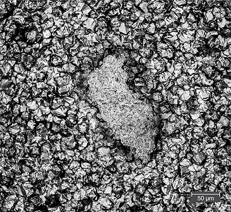 Irregularly shaped impurity center within a gold tarnish spot