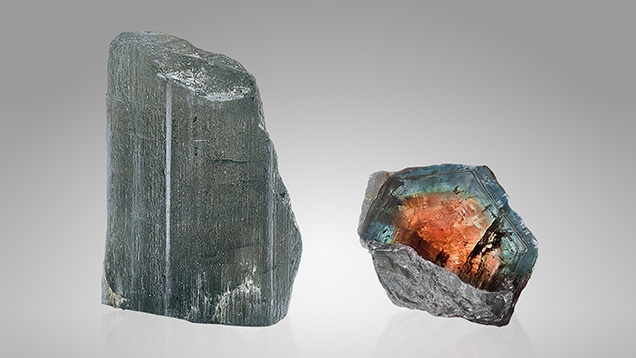 A 63.17 ct (26.70 × 17.24 × 15.23 mm) prismatic bicolor dumortierite rough crystal, viewed from the side (left) along with a cross-section view (right), displaying a pinkish orange core and a gray-blue outer layer. Photos by Lhapsin Nillapat.