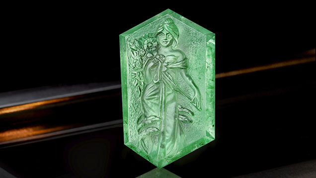 Figure 1. A Russian emerald carving, approximately 41 × 25 mm, of a woman holding blooming flowers, reportedly fashioned by Michael Peuster. Photo by Ronnakorn Manorotkul; courtesy of Tsarina Jewels.