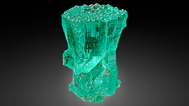Figure 1. This Colombian emerald (sample 10, 25.0 mm in length) shows conical habit in the upper part and prismatic habit in the lower part; the base is covered with numerous pointed hillocks. Photo by G. Martayan.